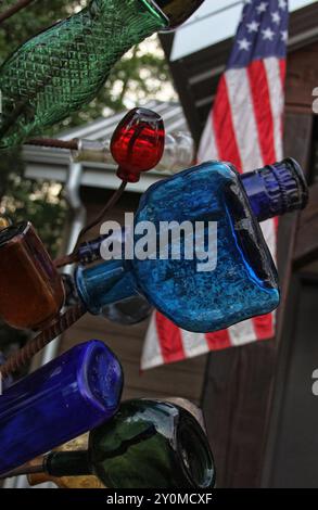 Klassische recycelte Flaschen auf Metallgestell mit amerikanischer Flagge Stockfoto