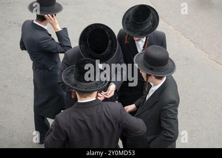 Eine Gruppe orthodoxer jüdischer Jungen, die in eine bestimmte Synagoge kommen, um Wohltätigkeit zu sammeln. Hier diskutieren sie ihre Ergebnisse. Im Rockland County, New York. Stockfoto