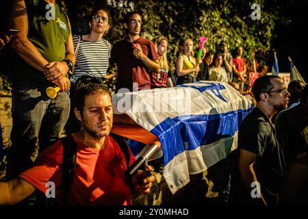 Ein Demonstrant hält während eines Protestes nach der Beerdigung von Hersh Goldberg Polin einen falschen Sarg. Zehntausende Menschen haben sich für einen zweiten Tag in Israel versammelt, nachdem die Leichen von Karmel Gat, Eden Yerushalmi, Hersh Goldberg-Polin, Alexander Lobanov, Almog Sarusi und Meister Sgt Ori Danino aus Gaza gerettet wurden. Demonstranten rufen Premierminister Benjamin Netanjahu und seine Regierung auf, eine Einigung zu erzielen, um die Freilassung der verbleibenden Geiseln zu erreichen, die von der Hamas während der Angriffe vom 7. Oktober ergriffen wurden. (Foto: Eyal Warshavsky/SOPA Images/SIPA USA) Stockfoto