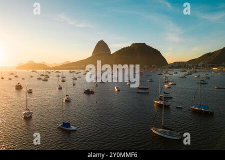 Viele kleine Boote in der Botafogo Bay mit dem Sugarloaf Mountain am Horizont bei Sonnenaufgang in Rio de Janeiro, Brasilien Stockfoto