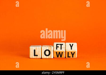 Symbol „hoch“ oder „niedrig“. Concept Words Lofty niedrig auf Holzblock. Schöner oranger Tisch mit orangefarbenem Hintergrund. Geschäftliches oder schwaches Konzept. Spac kopieren Stockfoto