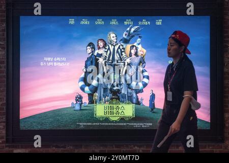 Seoul, Südkorea. September 2024. Eine Frau läuft am 3. September 2024 in Seoul, Südkorea, an einer Werbetafel von „Beetlejuice BeetleJuice“ vorbei. Der Film BeetleJuice BeetleJuice erscheint am 4. September in Südkorea. (Foto: Kichul Shin/NurPhoto) Credit: NurPhoto SRL/Alamy Live News Stockfoto