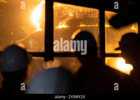 03. September 2024, Niedersachsen, Georgsmarienhütte: Bei einem Besuch des Stahlwerks Georgsmarienhütte GmbH stehen die Besucher vor einem Fenster, hinter dem ein DC-Lichtbogenofen in Betrieb ist und Schrott schmilzt. Foto: Michael Matthey/dpa Stockfoto