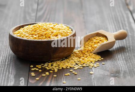 Rohe gelbe Linse in Schüssel auf hölzernem Hintergrund, (Linse culinaris) Stockfoto