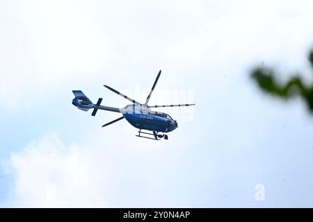 Wuppertal, Deutschland. September 2024. Ein Polizeihubschrauber fliegt über die Arbeitsagentur. Rund um die Arbeitsagentur in Wuppertal ist ein großer Polizeieinsatz im Gange. Mehr Kräfte und mindestens ein Hubschrauber seien vor Ort, sagte ein Polizeisprecher. Quelle: Roberto Pfeil/dpa/Alamy Live News Stockfoto