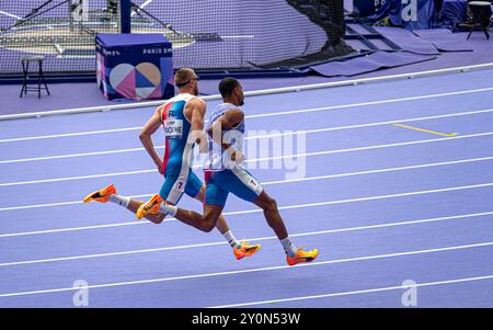 Der blinde französische Paralympic-Athlet Timothée Adolphe mit seinem Reiseleiter lief für die 400-m-Strecke im Stade de France für die Paralympischen Spiele 2024 in Paris. Stockfoto