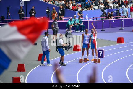 Der blinde französische Paralympic-Athlet Timothée Adolphe mit seinem Reiseleiter lief für die 400-m-Strecke im Stade de France für die Paralympischen Spiele 2024 in Paris. Stockfoto