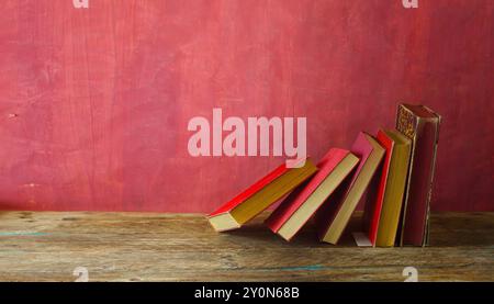 Reihe roter Bücher auf rotem grungy Hintergrund, Lesen, Lernen, Bildung oder Home Office Konzept Stockfoto