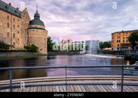 Das massive Orebro Castle ist eine Festung, die von dem Fluss Svartan bei Sonnenuntergang umgeben ist. Touristenattraktion und Geschichte Reiseziel. Schweden. C Stockfoto