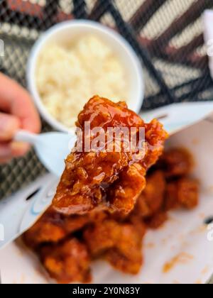 Knusprig gebratenes Huhn auf Gabel mit Saucy Glaze und Reisansicht auf Augenhöhe Stockfoto