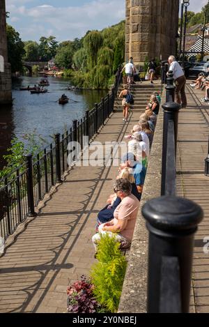 Senioren beobachten Boote auf dem Fluss Nidd, Knaresborough, North Yorkshire bei Sommersonne Stockfoto