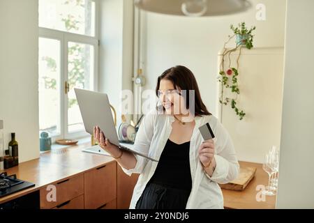 Eine fröhliche Frau genießt Online-Shopping, während sie sich in ihrer gemütlichen Küche entspannt. Stockfoto