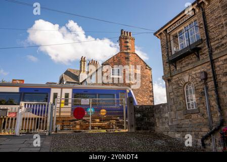 Der Zug fährt durch den Bahnhof Knaresborough, Knaresborough, North Yorkshire, Großbritannien mit Stellwerk und Kreuzung. Stockfoto