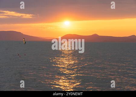 Wunderschöner Sonnenuntergang über dem Balaton mit einer Windsurferin Stockfoto