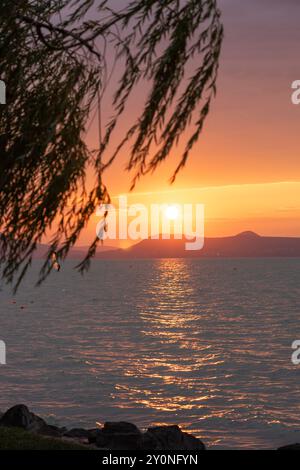 Wunderschöner Sonnenuntergang über dem Balaton mit einer Windsurferin Stockfoto