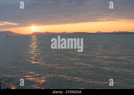 Wunderschöner Sonnenuntergang über dem Balaton mit einer Windsurferin Stockfoto