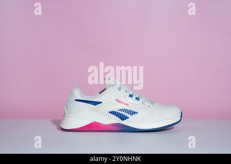 Straßburg, Frankreich - August 2024: Neue Trainingsschuhe Reebok Nano X4 auf rosa und weißem Hintergrund von der Seite. Stylische Schwarzweiß-Schuhe für aktive Stockfoto