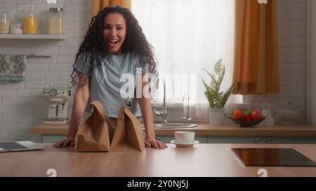 Kaukasisches Mädchen Hispanic Frau weibliche Hausfrau Kunde bestellen Essen schnell Express Lieferung Service kaufen Online Shopping Produkte Küche Laptop glücklich Stockfoto