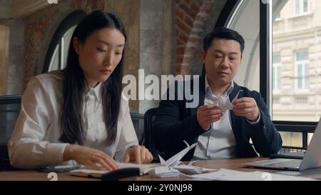 Zwei Geschäftskollegen Kollegen Asiatische Frau koreanische Geschäftsfrau weibliches Mädchen chinesischer Mann japanischer Geschäftsmann Mann Mann im Büro langweilig faul spielen Stockfoto