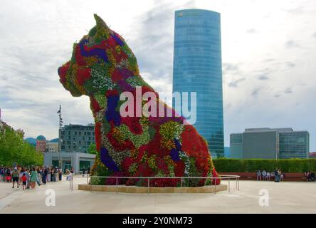 Welpenskulptur bedeckt mit Blumen von Jeff Koons vor dem Guggenheim Kunstmuseum mit dem Iberdola Turm Bilbao Baskenland Euskadi Spanien Stockfoto