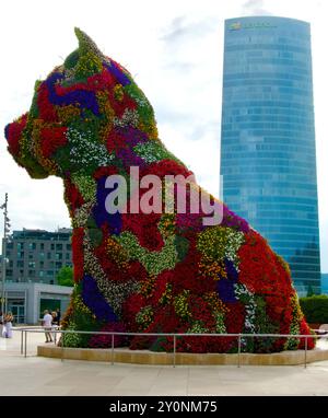 Welpenskulptur bedeckt mit Blumen von Jeff Koons vor dem Guggenheim Kunstmuseum mit dem Iberdola Turm Bilbao Baskenland Euskadi Spanien Stockfoto