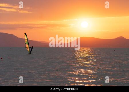Wunderschöner Sonnenuntergang über dem Balaton mit einer Windsurferin Stockfoto