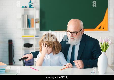 Porträt von Großvater und traurigen Enkel Schüler mit Problem im Klassenzimmer in der Schule. Stockfoto