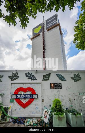 London, Großbritannien. September 2024. Am Tag vor der Veröffentlichung des Berichts über die Katastrophe des Grenfell Turms geht das Leben um die Gedenkmauer herum, während der Turm darüber aufragt. Die Beteiligten sind nach wie vor verärgert und frustriert darüber, dass niemand für die Tragödie zur Rechenschaft gezogen wurde, und hoffen, dass sich dies nach morgen ändern wird. Guy Bell/Alamy Live News Stockfoto