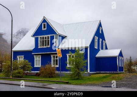 Traditionelles isländisch-blaues Wohngebäude mit weißen Fensterrahmen, verkleidet mit Wellblechen in Seydisfjordur Stadt in Island. Stockfoto