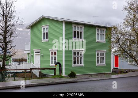 Traditionelles isländisches grünes Wohnhaus, weiße Fensterrahmen, verkleidet mit Wellblechen in Seydisfjordur Stadt in Island. Stockfoto