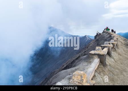 Touristen genießen die Aussicht vom Gipfel des Berges Bromo mit seinen vulkanischen Dämpfen in Java, indonesien Stockfoto