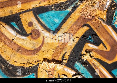 Abstraktes Detail aus Graffiti in Ocker- und Türkisfarben, gemalt an der Wand in Portugal Stockfoto