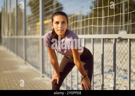 Die schöne junge, sportliche Frau hält während ihres Outdoor-Lauftrainings eine Weile an Stockfoto