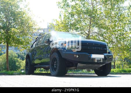 Bukarest, Rumänien - 28. Juli 2024: Ford F-150 SVT Raptor Black Pickup Truck auf Parkplatz in Wohngebieten in der Stadt. Vorderansicht Stockfoto