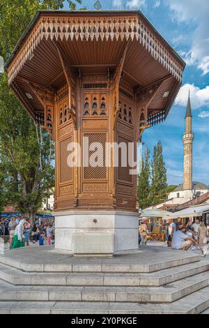 SARAJEVO, BOSNIEN UND HERZEGOWINA - 24. AUGUST 2024: Der berühmte Sebilj, ein Holzbrunnen im osmanischen Stil im Zentrum des Baščaršija-Platzes in Stockfoto