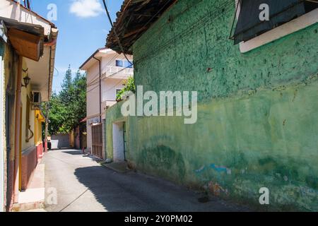 Eine ruhige Wohnstraße in der Innenstadt von Tirana, Zentralalbanien, gesäumt von bunten rustikalen Gebäuden Stockfoto