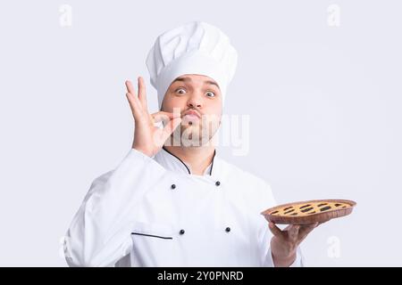 Chefkoch Guy Holding Pie Doing Zip Your Lip Gesture, Studio Stockfoto