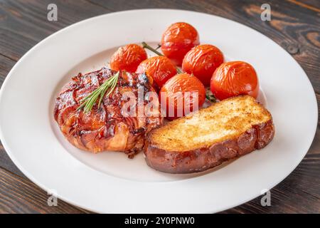 Camembert-Käserad mit glasiertem Speck gewickelt Stockfoto