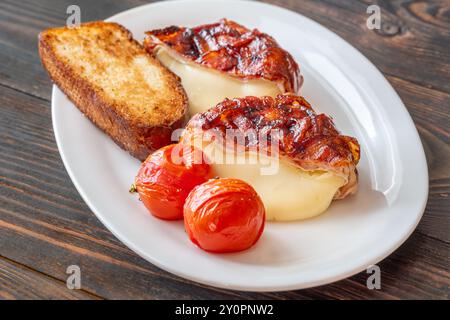 Camembert-Käserad mit glasiertem Speck gewickelt Stockfoto