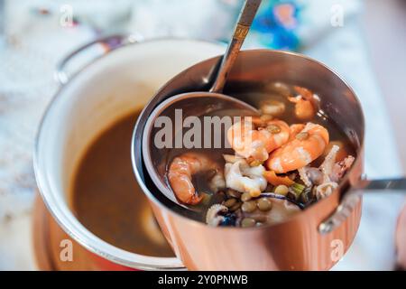 Suppe aus Meeresprodukten und Baguette-Brot als Hintergrund Stockfoto