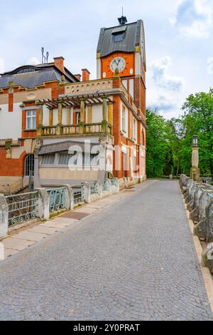 Das atemberaubende Jugendstil-Wasserkraftwerk Hucak in Hradec Kralove bietet eine komplexe Architektur inmitten von Grün und einem Kopfsteinpflasterweg. Stockfoto