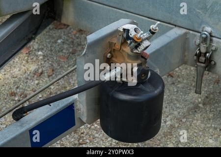 Eine detaillierte Ansicht einer hydraulischen Kupplung am Rahmen eines Anhängers, die das Flüssigkeitssystem zeigt. Stockfoto