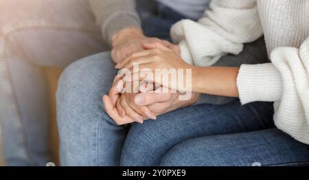 Nicht Erkennbares Paar Hält Die Hände Auf Der Couch Im Innenbereich, Zugeschnitten Stockfoto