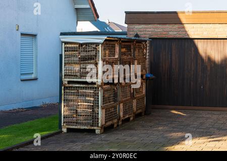 Gesägtes Brennholz für den Kamin in Metallbehältern vor dem Garagentor. Stockfoto