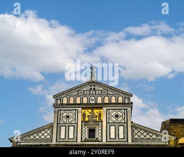 Hoher Teil der mittelalterlichen Basilika San Miniato al Monte vor blauem bewölktem Himmel, Florenz, Toskana, Italien Stockfoto