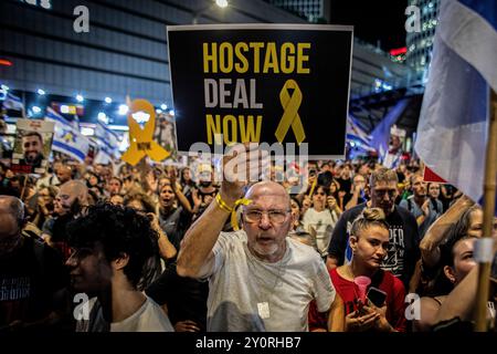 Tel Aviv, 03.09.2024, ein israelischer Demonstrant hält während einer Demonstration außerhalb des Verteidigungsministeriums in Tel Aviv am Dienstag, 3. September 2024, ein Schild auf, das zu einem Geiselabkommen aufruft.Tausende Menschen haben sich in Tel Aviv und ganz Israel versammelt, drei Tage nachdem die Leichen von Carmel Gat, Eden Yerushalmi, Hersh Goldberg-Polin, Alexander Lobanov, Almog Sarusi und Meister Ori Danino aus Gaza gerettet wurden. Die Demonstranten rufen Premierminister Benjamin Netanjahu und seine Regierung auf, eine Einigung zu erzielen, um die Freilassung der verbleibenden Geiseln zu erreichen, die die Hamas während der Angriffe vom 7. Oktober ergriffen hat. Foto von Eyal war Stockfoto