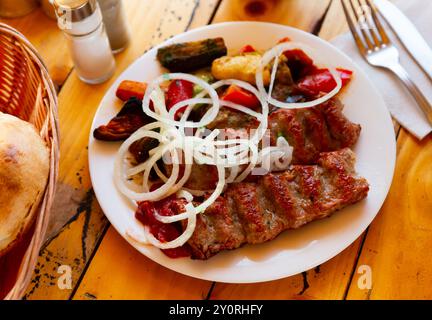 Gegrillter lula Kebab – Fleischgericht mit Gemüse und Zwiebeln. Beliebte orientalische Gerichte aus der Nähe Stockfoto