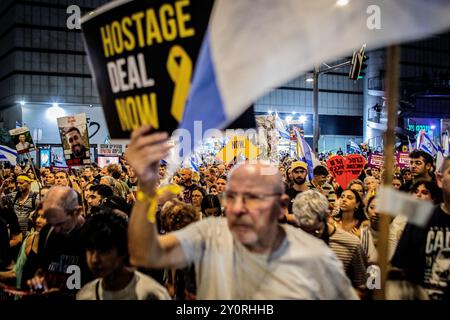 Tel Aviv, 03.09.2024, ein israelischer Demonstrant hält während einer Demonstration außerhalb des Verteidigungsministeriums in Tel Aviv am Dienstag, 3. September 2024, ein Schild auf, das zu einem Geiselabkommen aufruft.Tausende Menschen haben sich in Tel Aviv und ganz Israel versammelt, drei Tage nachdem die Leichen von Carmel Gat, Eden Yerushalmi, Hersh Goldberg-Polin, Alexander Lobanov, Almog Sarusi und Meister Ori Danino aus Gaza gerettet wurden. Die Demonstranten rufen Premierminister Benjamin Netanjahu und seine Regierung auf, eine Einigung zu erzielen, um die Freilassung der verbleibenden Geiseln zu erreichen, die die Hamas während der Angriffe vom 7. Oktober ergriffen hat. Foto von Eyal war Stockfoto