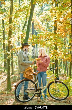 Junges Hipster-Paar, das ein romantisches Date im Wald hat und in der Nähe des Fahrrads gegeneinander steht. Erste wirklich ernste Beziehung. Erstes Datum Stockfoto