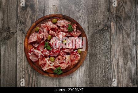 Sortiment, Fleischvorspeise in Scheiben, Schinken, Salami und Schinken, mit Oliven, auf einem Holzbrett, Frühstück, Blick von oben, Nahaufnahme, keine Leute Stockfoto